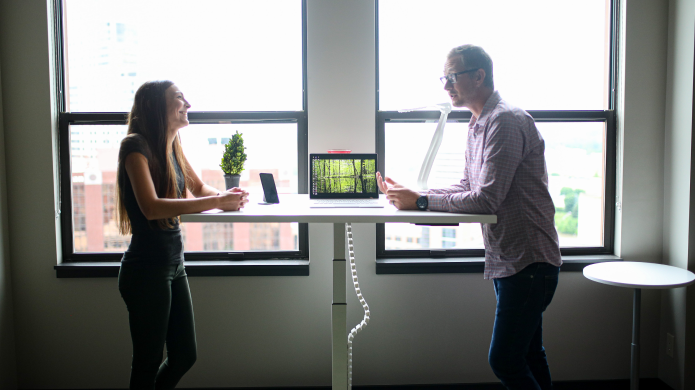 a man and a woman standing near a table