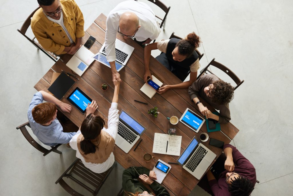 people with laptops around a table