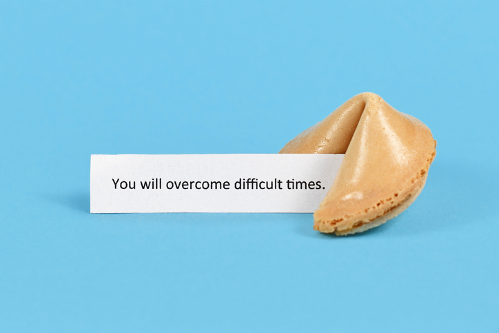 Fortune cookie with motivational text on paper saying