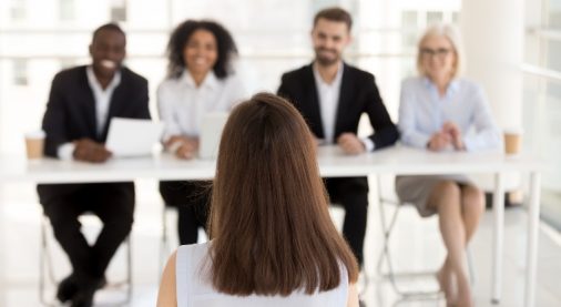 Back view of female job applicant make good first impression at work interview in office, millennial woman candidate talk, impress HR managers or recruiters at hiring. Employment concept (Back view of female job applicant make good first impression at