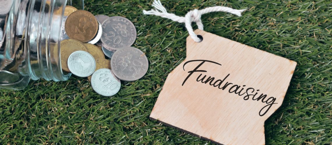 Coins and wooden tag written with FUNDRAISING.