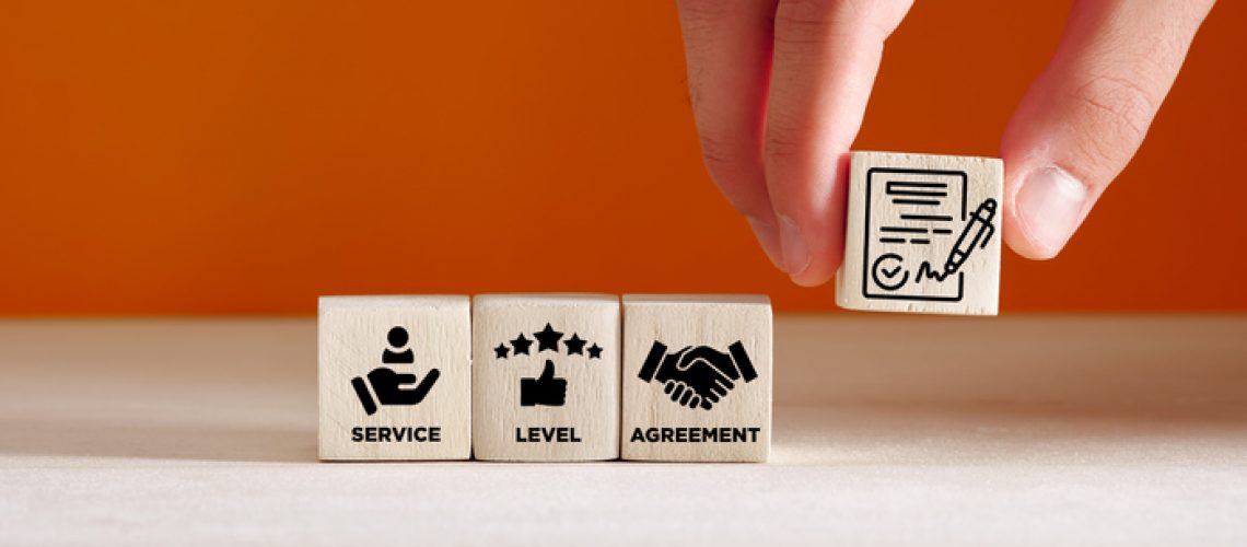 Service Level Agreement SLA business concept. Hand puts wooden cubes with Service Level Agreement symbols.