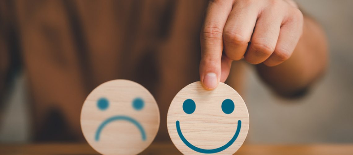 customer services best excellent business rating experience. Satisfaction survey concept. Hand of a businessman chooses a smile face on wood block.