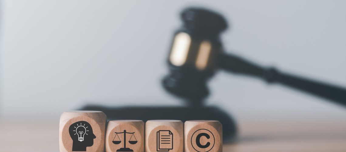 wooden blocks and Wooden judge gavel on the table, concept of copyright or intellectual property patent protection of copyright infringement proprietary declaration Legitimate innovations wooden blocks and Wooden judge gavel on the table, concept of copyright or intellectual property patent protection of copyright infringement proprietary declaration Legitimate innovations