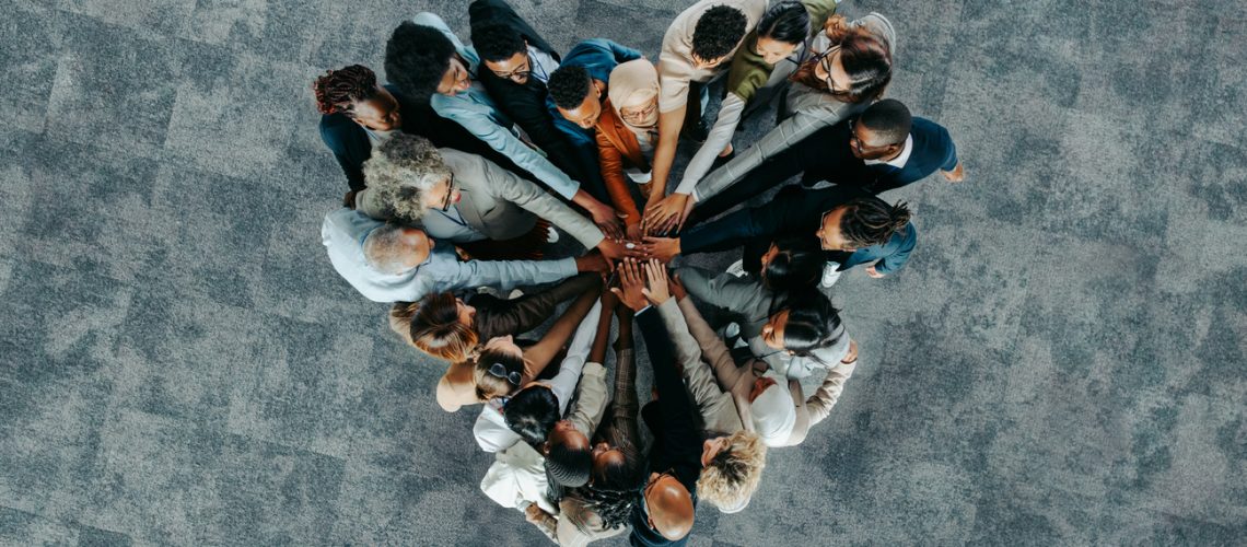 A diverse business group standing in a heart formation, symbolizing unity, teamwork, and collaboration.