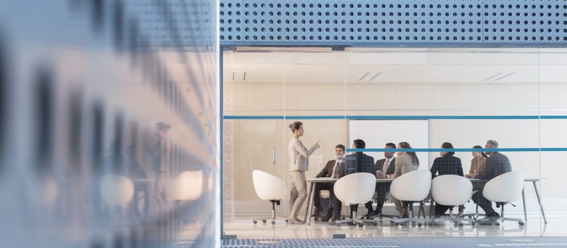 Businesswoman leading meeting in modern conference room