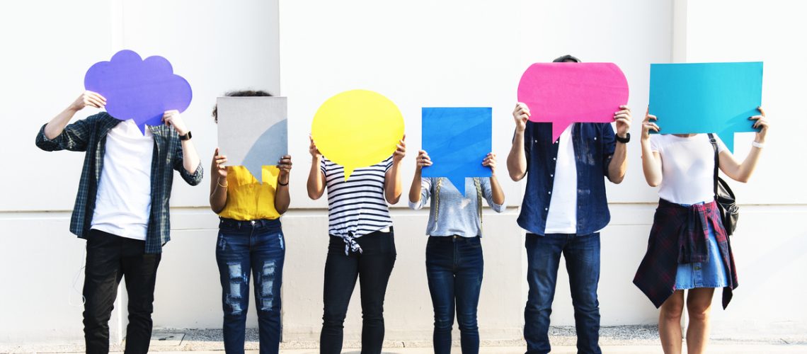 Young adult friends holding up copy space placard thought bubbles