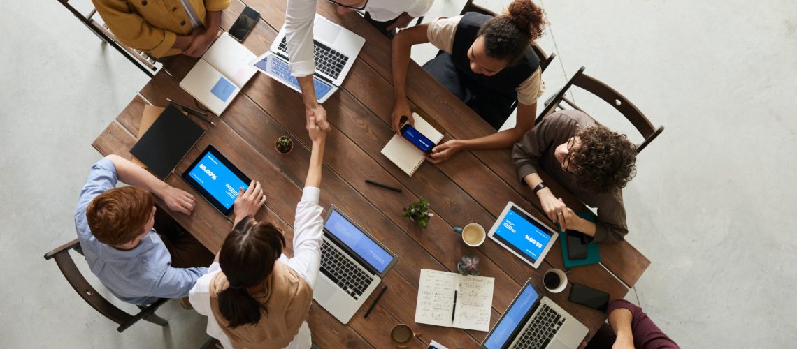 people with laptops around a table